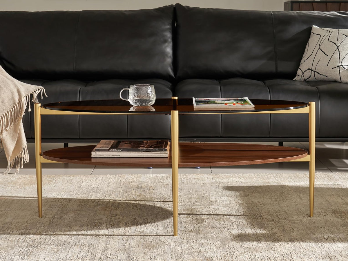 Shrine Oval Coffee Table, Mid-Century Modern Design, 2-Tier Structure, Clear Glass Top and White MDF Shelf, 47" D x 21" W x 17" H, Sleek Conical Metal Legs with Gold Finish