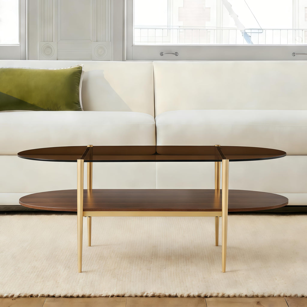 Shrine Oval Coffee Table, Mid-Century Modern Design, 2-Tier Structure, Clear Glass Top and White MDF Shelf, 47" D x 21" W x 17" H, Sleek Conical Metal Legs with Gold Finish