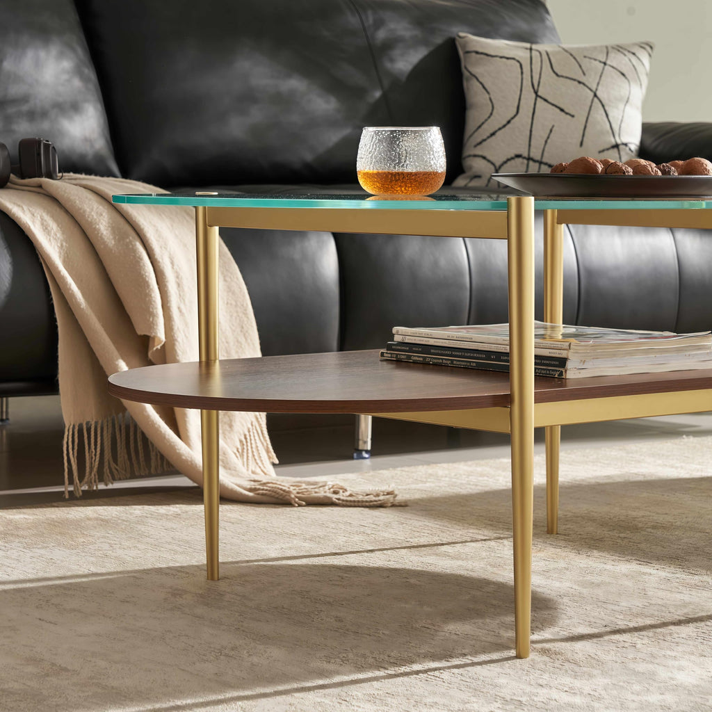 Shrine Oval Coffee Table, Mid-Century Modern Design, 2-Tier Structure, Clear Glass Top and White MDF Shelf, 47" D x 21" W x 17" H, Sleek Conical Metal Legs with Gold Finish