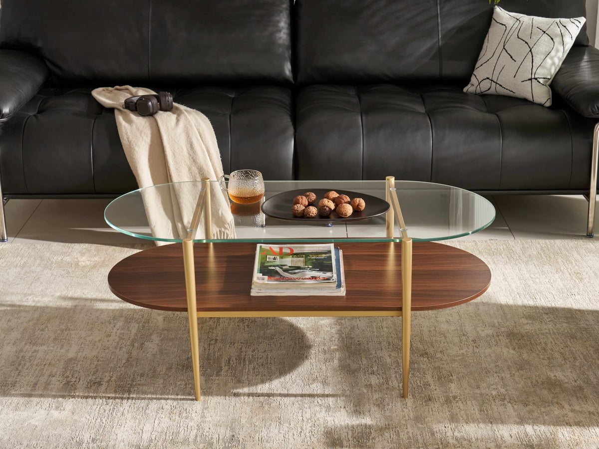 Shrine Oval Coffee Table, Mid-Century Modern Design, 2-Tier Structure, Clear Glass Top and White MDF Shelf, 47" D x 21" W x 17" H, Sleek Conical Metal Legs with Gold Finish